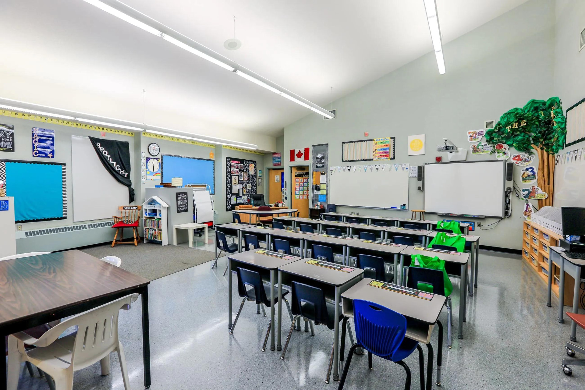 Bright elementary classroom with desks and whiteboards